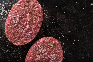 Burger, ızgara, Barbekü, Barbekü için et. Taze, lezzetli pişmemiş baharatlı sığır eti hamburger kopya alanı closeup ile koyu arka plan üzerinde için