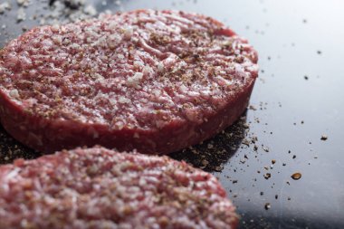 Burger, ızgara, Barbekü, Barbekü için et. Taze, lezzetli pişmemiş baharatlı sığır eti hamburger kopya alanı closeup ile koyu arka plan üzerinde için
