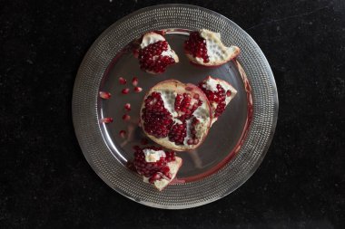 Karanlık mermer zemin üzerine kırmızı sulu nar. Sağlıklı, antioksidan, taze, gurme, lezzetli, organik meyve. Nar suyu için madde. Yakın çekim ve kopya alanı