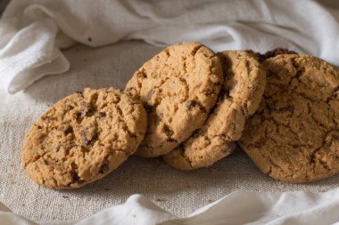 İle ışık Tekstil zemin üzerine Çikolata parçalı kurabiye kazık. Kahvaltı, Kahvaltı ve öğle yemeği için lezzetli sabah aperatifler. Apetisant, sağlıklı, tatlı, scrummy ve fast food