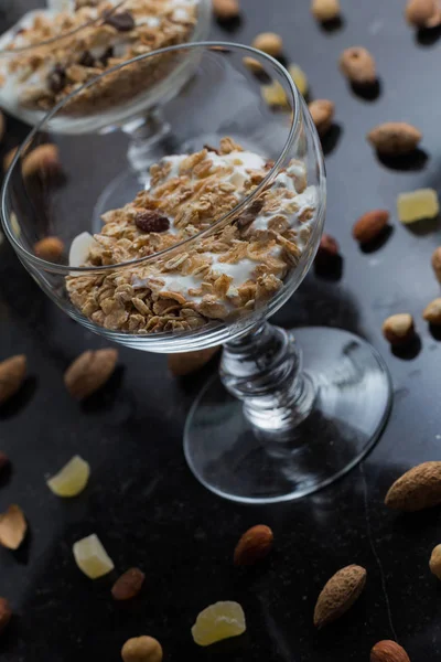 Granola yoğurt, fındık ve koyu arka plan üzerinde cam kase meyve ile. Kahvaltı için lezzetli, sağlıklı tatlı tatlı. Mısır gevreği, müsli. Kopya alanı, portre
