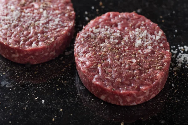 Burger, ızgara, Barbekü, Barbekü için et. Taze, lezzetli pişmemiş baharatlı sığır eti hamburger kopya alanı closeup ile koyu arka plan üzerinde için