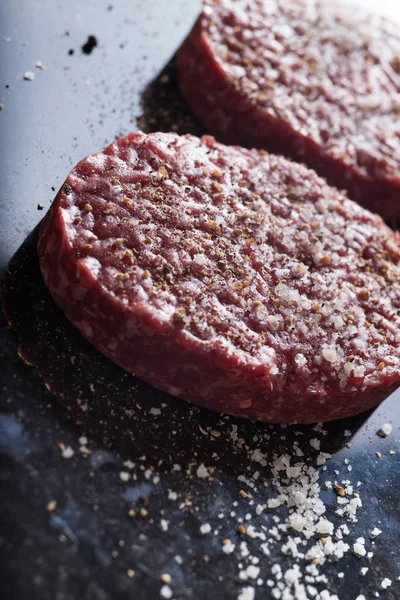 Burger, ızgara, Barbekü, Barbekü için et. Taze, lezzetli pişmemiş baharatlı sığır eti hamburger kopya alanı closeup ile koyu arka plan üzerinde için