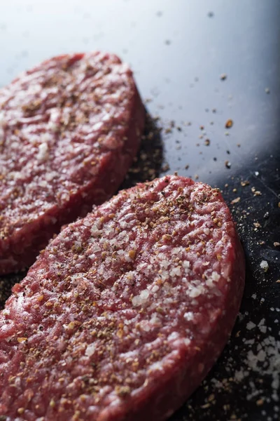 Burger, ızgara, Barbekü, Barbekü için et. Taze, lezzetli pişmemiş baharatlı sığır eti hamburger kopya alanı closeup ile koyu arka plan üzerinde için