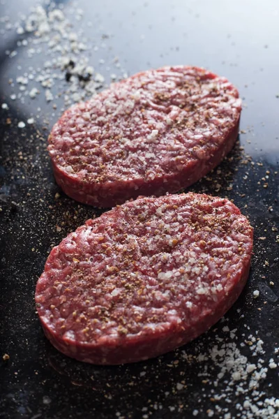 Burger, ızgara, Barbekü, Barbekü için et. Taze, lezzetli pişmemiş baharatlı sığır eti hamburger kopya alanı closeup ile koyu arka plan üzerinde için