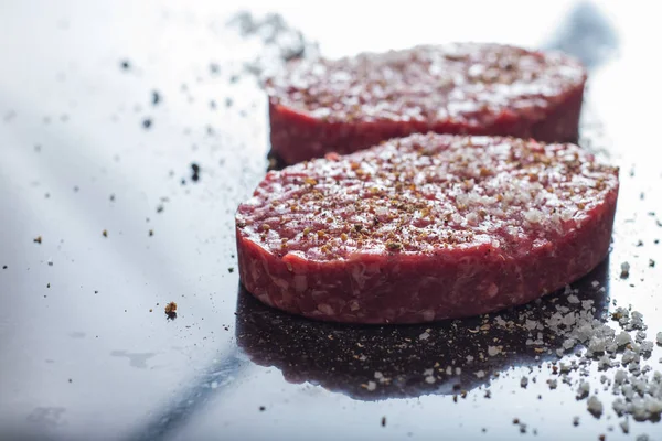 Burger, ızgara, Barbekü, Barbekü için et. Taze, lezzetli pişmemiş baharatlı sığır eti hamburger kopya alanı closeup ile koyu arka plan üzerinde için