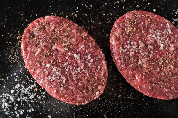 Burger, ızgara, Barbekü, Barbekü için et. Taze, lezzetli pişmemiş baharatlı sığır eti hamburger kopya alanı closeup ile koyu arka plan üzerinde için