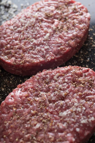 Burger, ızgara, Barbekü, Barbekü için et. Taze, lezzetli pişmemiş baharatlı sığır eti hamburger kopya alanı closeup ile koyu arka plan üzerinde için