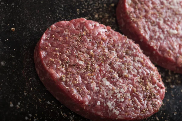 Burger, ızgara, Barbekü, Barbekü için et. Taze, lezzetli pişmemiş baharatlı sığır eti hamburger kopya alanı closeup ile koyu arka plan üzerinde için