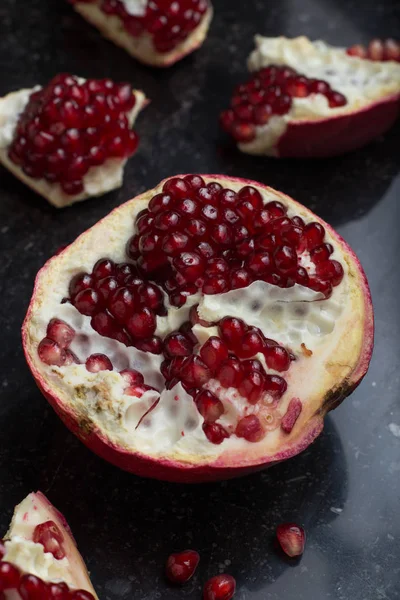 Karanlık mermer zemin üzerine kırmızı sulu nar. Sağlıklı, antioksidan, taze, gurme, lezzetli, organik meyve. Nar suyu için madde. Yakın çekim ve kopya alanı