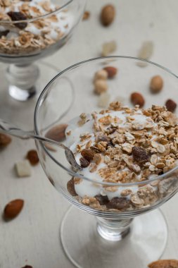 Granola yoğurt, fındık ve açık renkli cam kase meyve ile. Kahvaltı için lezzetli, sağlıklı tatlı tatlı. Mısır gevreği, müsli. Kopya alanı, portre