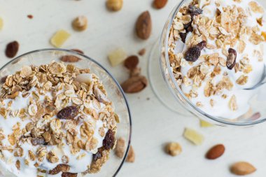 Granola yoğurt, fındık ve açık renkli cam kase meyve ile. Kahvaltı için lezzetli, sağlıklı tatlı tatlı. Mısır gevreği, müsli. Kopya alanı, portre