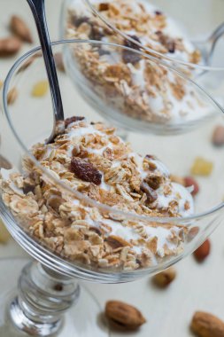 Granola yoğurt, fındık ve açık renkli cam kase meyve ile. Kahvaltı için lezzetli, sağlıklı tatlı tatlı. Mısır gevreği, müsli. Kopya alanı, portre