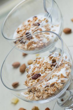 Granola yoğurt, fındık ve açık renkli cam kase meyve ile. Kahvaltı için lezzetli, sağlıklı tatlı tatlı. Mısır gevreği, müsli. Kopya alanı, portre