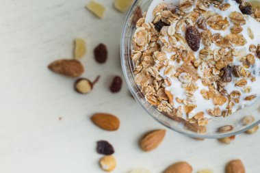 Granola yoğurt, fındık ve açık renkli cam kase meyve ile. Kahvaltı için lezzetli, sağlıklı tatlı tatlı. Mısır gevreği, müsli. Kopya alanı, portre