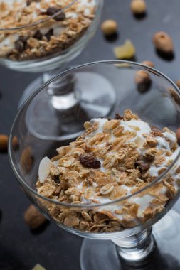 Granola yoğurt, fındık ve koyu arka plan üzerinde cam kase meyve ile. Kahvaltı için lezzetli, sağlıklı tatlı tatlı. Mısır gevreği, müsli. Kopya alanı, portre