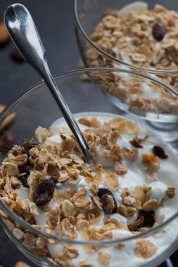 Granola yoğurt, fındık ve koyu arka plan üzerinde cam kase meyve ile. Kahvaltı için lezzetli, sağlıklı tatlı tatlı. Mısır gevreği, müsli. Kopya alanı, portre