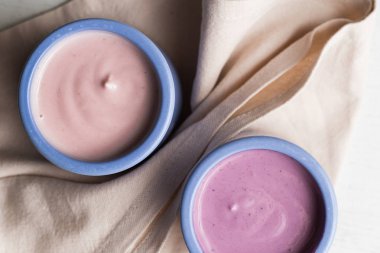 Ahşap ligth zemin üzerine seramik kase yoğurt ürün yelpazesine sahip. Doğal ve sağlıklı meyve, diyet, gurme tatlı granola kahvaltı için. Tatlı yoğurt portre