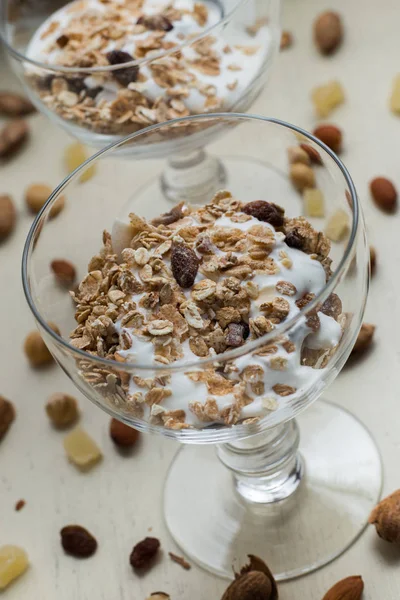 Granola yoğurt, fındık ve açık renkli cam kase meyve ile. Kahvaltı için lezzetli, sağlıklı tatlı tatlı. Mısır gevreği, müsli. Kopya alanı, portre