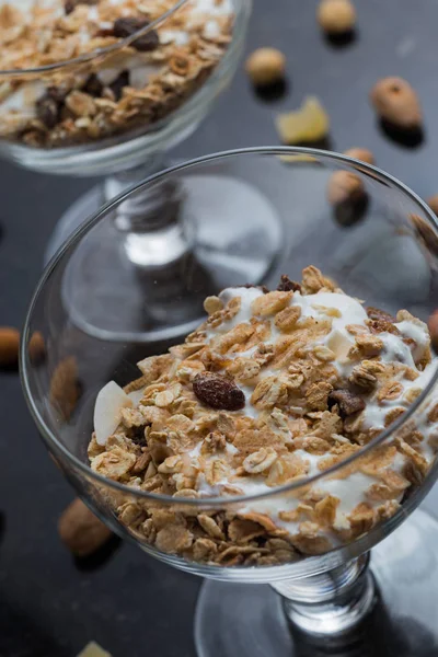 Granola yoğurt, fındık ve koyu arka plan üzerinde cam kase meyve ile. Kahvaltı için lezzetli, sağlıklı tatlı tatlı. Mısır gevreği, müsli. Kopya alanı, portre