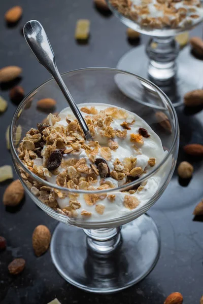 Granola yoğurt, fındık ve koyu arka plan üzerinde cam kase meyve ile. Kahvaltı için lezzetli, sağlıklı tatlı tatlı. Mısır gevreği, müsli. Kopya alanı, portre