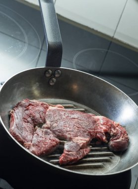 Izgara biftek ızgara tava üzerinde. Bir mutfak pişirme biftek. Kopyalama alanı closeup ile taze, lezzetli, baharatlı, sulu et