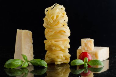 Makarna Tagliatelle, parmesan mermer masaya düzenlenmiştir. Geleneksel İtalyan mutfağı yemek için lezzetli kuru pişmemiş maddeler. Ham closeup arka plan. Üstten Görünüm. Kopya alanı