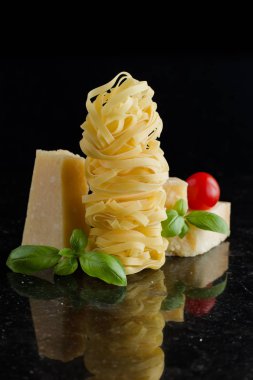 Makarna Tagliatelle, parmesan mermer masaya düzenlenmiştir. Geleneksel İtalyan mutfağı yemek için lezzetli kuru pişmemiş maddeler. Ham closeup arka plan. Üstten Görünüm. Kopya alanı