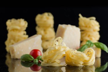 Makarna Tagliatelle, parmesan mermer masaya düzenlenmiştir. Geleneksel İtalyan mutfağı yemek için lezzetli kuru pişmemiş maddeler. Ham closeup arka plan. Üstten Görünüm. Kopya alanı