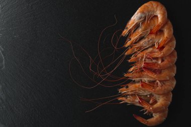 Siyah arka plan üzerine karides. Lezzetli deniz ürünleri meze haşlama veya ızgara baharatlar ile servis. Yakın çekim. Üstten Görünüm