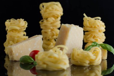 Makarna Tagliatelle, parmesan mermer masaya düzenlenmiştir. Geleneksel İtalyan mutfağı yemek için lezzetli kuru pişmemiş maddeler. Ham closeup arka plan. Üstten Görünüm. Kopya alanı