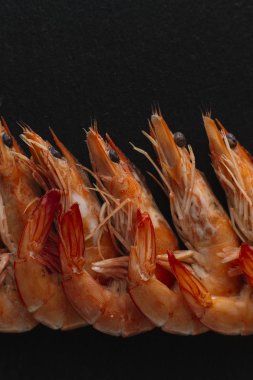 Siyah arka plan üzerine karides. Lezzetli deniz ürünleri meze haşlama veya ızgara baharatlar ile servis. Yakın çekim. Üstten Görünüm