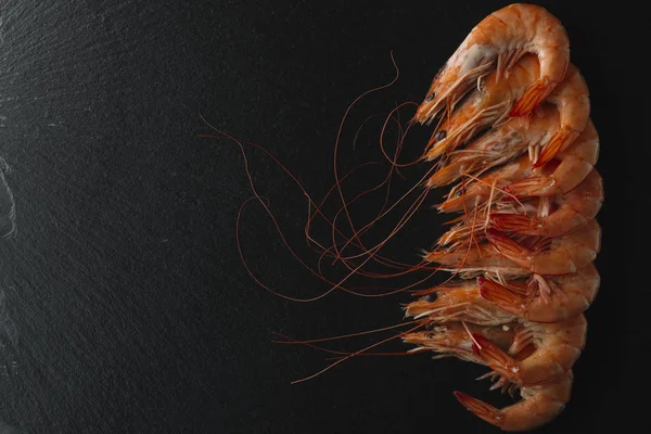 Siyah arka plan üzerine karides. Lezzetli deniz ürünleri meze haşlama veya ızgara baharatlar ile servis. Yakın çekim. Üstten Görünüm