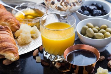 Kahvaltı çeşitli yoğurt, granola, kahve, meyve suyu, kruvasan, zeytin. Meze sabah yemekleri ile karıştırın. Koyu arka plan üzerinde sağlıklı, taze, lezzetli yemek. Üstten Görünüm. Kopya alanı
