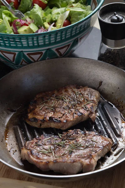 Biftek salata ve baharat ile karanlık tabloda. Taze, lezzetli pişmiş et kopya alanı closeup ile bir ızgara üzerinde