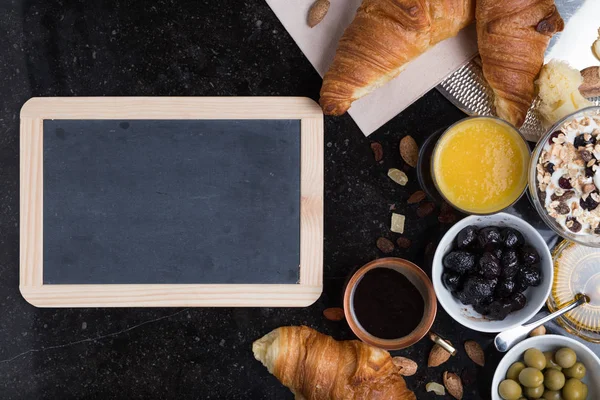 Colazione assortiti yogurt, muesli, caffè, succo di frutta, croissant, olive. Miscela antipasto con piatti del mattino. Cibo sano, fresco e delizioso su sfondo scuro. Vista dall'alto. Copia spazio — Foto Stock