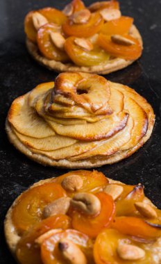 Kayısı ve elma tart. Karanlık mermer zemin üzerine meyve ile geleneksel Fransız pasta. Bir şekilde dekore edilmiş badem ve nane yaprakları. Kopyalama alanı closeup ile lezzetli tatlı
