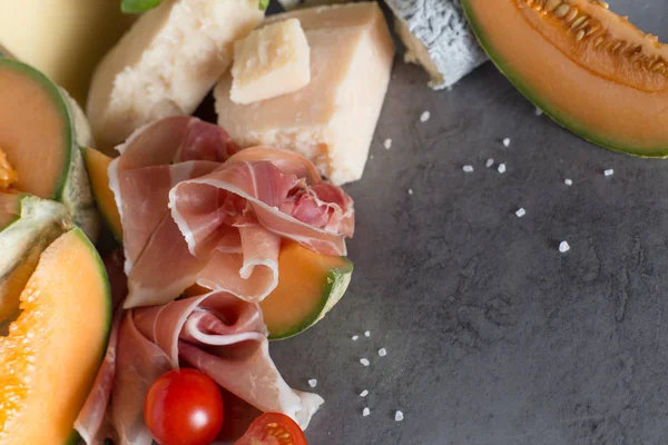 Jambon karışımı. Jambon. Geleneksel İtalyan ve İspanyol Tuzlama, Sigara, Kuru tedavi çanak - jamon Serrano ve prosciutto crudo gri arka plan üzerinde kavun ile dilimlenmiş. Uzay kopyalayın. Portre