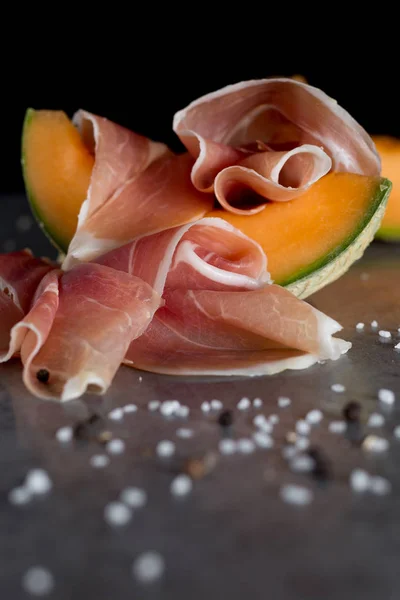 Miscela Jambon. Prosciutto. Salatura tradizionale italiana e spagnola, affumicatura, piatto stagionato a secco - jamon Serrano e prosciutto crudo affettato con melone su fondo grigio. Ricevuto. Primo piano — Foto Stock