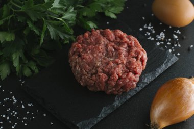 Çiğ biftek. Sığır eti çiğ et baharat, ot ve yumurta sarısı ile kıyılmış. Taze, baharatlı, lezzetli, gurme yemek ile kopya alanı, koyu arka plan üzerinde yakın çekim.