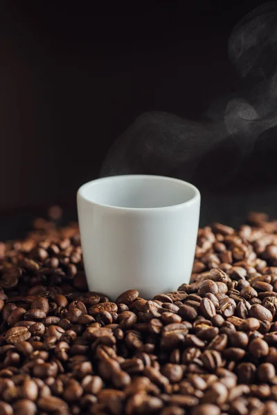 Cangkir Espresso penuh dengan kopi di tumpukan biji-bijian. Italian tradisional pagi minuman pendek saat sarapan. Close-up. Toned — Stok Foto