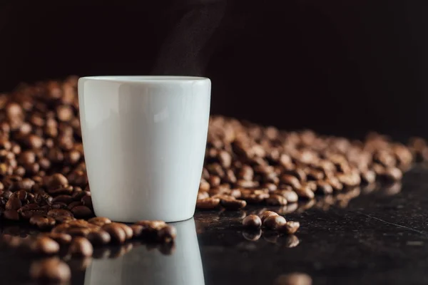 Espresso-kopje koffie op de korrels stapel vol. Italiaanse traditionele ochtend korte drankje op ontbijt. Close-up. Toned — Stockfoto
