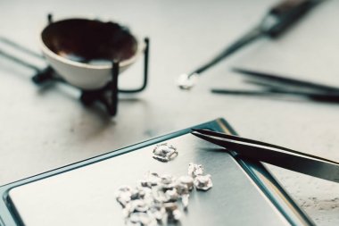 Takı araçları. Takı. Goldsmith işyeri, çalışma alanında açık renkli. El tekne. Atölye. Üretim. Ağırlık pullarla granül metal gümüş ve platin. Portre. Tonda