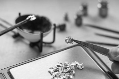 Takı araçları. Takı. Goldsmith işyeri, çalışma alanında açık renkli. El tekne. Atölye. Üretim. Ağırlık pullarla granül metal gümüş ve platin. Portre. Tonda