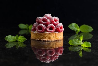 Ahududulu tart tatlı koyu arka plan üzerinde. Geleneksel Fransız tatlı pasta. Lezzetli, iştah açıcı, ev yapımı Pasta krema, taze meyveler ve meyve ile. Alan, closeup kopyalayın. Seçici odak