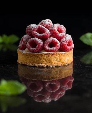 Ahududulu tart tatlı koyu arka plan üzerinde. Geleneksel Fransız tatlı pasta. Lezzetli, iştah açıcı, ev yapımı Pasta krema, taze meyveler ve meyve ile. Alan, closeup kopyalayın. Seçici odak
