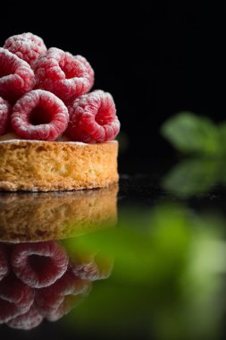 Ahududulu tart tatlı koyu arka plan üzerinde. Geleneksel Fransız tatlı pasta. Lezzetli, iştah açıcı, ev yapımı Pasta krema, taze meyveler ve meyve ile. Alan, closeup kopyalayın. Seçici odak