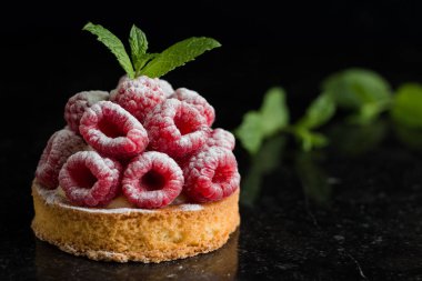 Ahududulu tart tatlı koyu arka plan üzerinde. Geleneksel Fransız tatlı pasta. Lezzetli, iştah açıcı, ev yapımı Pasta krema, taze meyveler ve meyve ile. Alan, closeup kopyalayın. Seçici odak