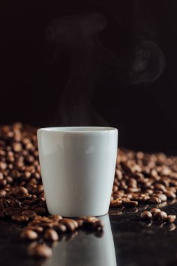 Espresso fincan kahve taneleri yığın üzerinde tam. İtalyan geleneksel sabah kısa içmek kahvaltı. Yakın çekim. Tonda