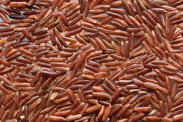 Red rice, grains closeup. Bhutanese. Unpolished, uncooked, natural, diet, raw for traditional asian cuisine, dish. Popular agriculture cereal. Texture pattern background, copy space — Stock Photo, Image